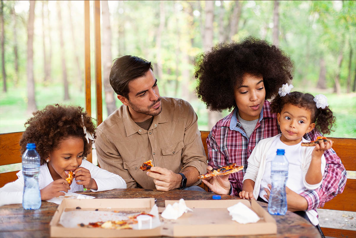 Diverse family on vacation having pizza